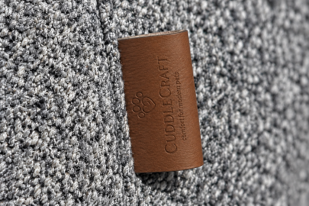 CUDDLE CRAFT COZY BED in Warm Grey — fabric and leather label close-up